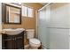 This cozy bathroom features a glass shower door, a dark sink vanity, and updated toilet at 7553 Durham Hall Ave # 201, Las Vegas, NV 89130