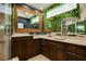 Elegant bathroom featuring dark wood cabinets, marble countertops, decorative mirrors, and a garden wall at 7625 Coley Ave, Las Vegas, NV 89117