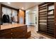 Walk-in closet featuring custom cabinets, shelves, drawers, and an island; open to an adjoining bathroom at 7625 Coley Ave, Las Vegas, NV 89117