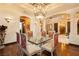 Opulent dining room with a glass table, decorative chairs, detailed ceiling design, and hardwood floors at 7625 Coley Ave, Las Vegas, NV 89117