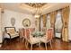 Well-appointed dining room with hardwood floors, custom drapes, a glass table, and seating for six guests for formal dining at 7625 Coley Ave, Las Vegas, NV 89117