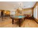 Inviting game room with a pool table, wood floors, and elegant lighting fixture at 7625 Coley Ave, Las Vegas, NV 89117