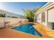 Relaxing pool with waterfall feature, surrounded by a vibrant orange deck and privacy wall at 7625 Coley Ave, Las Vegas, NV 89117