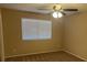 Cozy bedroom with neutral walls, carpet, a ceiling fan, and bright natural light provided by the window at 7912 Foxwood Pl # 104, Las Vegas, NV 89145