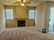Spacious living room featuring a cozy fireplace, neutral carpet, and bright natural light from the windows at 7912 Foxwood Pl # 104, Las Vegas, NV 89145