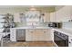 Cozy kitchen with white cabinets, stainless steel appliances, and tile countertops; with maple leaf accents at 7920 Aviano Pines Ave, Las Vegas, NV 89129