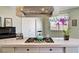 Kitchen island with a stovetop, tile countertops, ample storage, and a stylish range hood at 7920 Aviano Pines Ave, Las Vegas, NV 89129