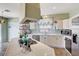 Open-concept kitchen with island cooktop, stainless appliances, tile countertops, cabinets and decor accents at 7920 Aviano Pines Ave, Las Vegas, NV 89129