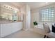 Bright bathroom features a tub, shower, dual sinks, and block glass window at 7986 Merlewood Ave, Las Vegas, NV 89117