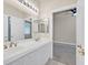 Bright ensuite bathroom with double sink vanity and a doorway leading into a carpeted bedroom at 7986 Merlewood Ave, Las Vegas, NV 89117