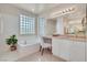 Bright bathroom features a bathtub with block glass windows and vanity area at 7986 Merlewood Ave, Las Vegas, NV 89117