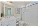 Well-lit bathroom with white vanity, framed mirror, and enclosed tile shower offering a clean, modern aesthetic at 7986 Merlewood Ave, Las Vegas, NV 89117