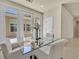 Chic dining area with a glass-top table and white chairs, adjacent to sliding glass doors at 7986 Merlewood Ave, Las Vegas, NV 89117