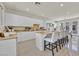 Bright kitchen featuring white cabinetry, granite countertops, and a spacious island with bar stool seating at 7986 Merlewood Ave, Las Vegas, NV 89117