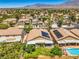 High aerial view showcasing homes with solar panels, swimming pools, and lush landscaping in a suburban setting at 8089 Black Orchid Ave, Las Vegas, NV 89131