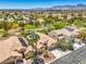 A high-angle aerial showcasing homes with solar panels and landscaping, set against a backdrop of distant mountains at 8089 Black Orchid Ave, Las Vegas, NV 89131