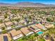 An elevated aerial view showcasing a suburban community with tree-lined streets, solar panels, and mountain views at 8089 Black Orchid Ave, Las Vegas, NV 89131