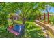 Serene backyard featuring a bench, mature tree, and stone-lined flower bed, creating a peaceful retreat at 8089 Black Orchid Ave, Las Vegas, NV 89131