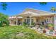 Charming backyard featuring a covered patio, lush lawn, and well-maintained landscaping in a suburban setting at 8089 Black Orchid Ave, Las Vegas, NV 89131