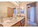 Well-lit bathroom featuring double sinks, modern faucets, and a neutral color scheme at 8089 Black Orchid Ave, Las Vegas, NV 89131