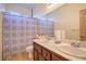 Bathroom featuring double sinks, a large mirror, and decorative shower curtain at 8089 Black Orchid Ave, Las Vegas, NV 89131