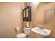 Half bath features a pedestal sink, decorative mirror, and updated fixtures at 8089 Black Orchid Ave, Las Vegas, NV 89131