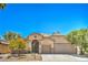 Charming single-story home featuring desert landscaping, an attached garage, and a warm, inviting facade at 8089 Black Orchid Ave, Las Vegas, NV 89131