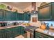 Well-equipped kitchen with green cabinets, granite countertops, and stainless steel range at 8089 Black Orchid Ave, Las Vegas, NV 89131