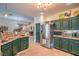 Well-lit kitchen featuring custom green cabinetry, stainless steel appliances, and tile flooring at 8089 Black Orchid Ave, Las Vegas, NV 89131