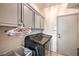 Modern laundry room featuring gray cabinetry, tile floors, and a front-load washer/dryer at 8089 Black Orchid Ave, Las Vegas, NV 89131