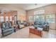 Comfortable living room with tile flooring, plush seating, and large windows, creating a relaxed and bright atmosphere at 8089 Black Orchid Ave, Las Vegas, NV 89131
