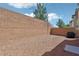 Spacious backyard with a brick wall, desert landscaping, and a grill under a cover at 914 Appaloosa Hills Ave, North Las Vegas, NV 89081