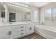 Bright bathroom with double sinks, white cabinetry, a large mirror, and a separate tub and shower at 914 Appaloosa Hills Ave, North Las Vegas, NV 89081