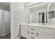 Bright bathroom featuring dual sinks, a large mirror, and a shower with a curtain at 914 Appaloosa Hills Ave, North Las Vegas, NV 89081