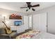 Well-lit bedroom featuring a ceiling fan, a cozy chair with a guitar, a TV, and a closet at 914 Appaloosa Hills Ave, North Las Vegas, NV 89081
