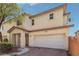Tan two-story home with a two-car garage, brick driveway, and manicured landscaping at 914 Appaloosa Hills Ave, North Las Vegas, NV 89081