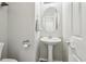 Bright half bathroom with modern fixtures, a pedestal sink, and a decorative mirror at 914 Appaloosa Hills Ave, North Las Vegas, NV 89081