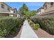 Community walking path with lush green hedges, trees, and a sidewalk for an active lifestyle at 914 Appaloosa Hills Ave, North Las Vegas, NV 89081