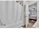 Bright bathroom with tub and shower featuring a white shower curtain, plus views into the bedroom at 9141 Careful Canvas Ave, Las Vegas, NV 89149
