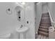 Cozy bathroom with a white pedestal sink and a stairway off the bathroom at 9141 Careful Canvas Ave, Las Vegas, NV 89149