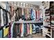 Walk-in closet featuring ample storage shelves, double racks for hanging clothes and overhead storage containers at 9141 Careful Canvas Ave, Las Vegas, NV 89149