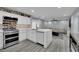 Modern kitchen with a stainless steel stove, white cabinets, marble countertops, and wood-look floors at 9141 Careful Canvas Ave, Las Vegas, NV 89149