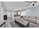 Open-concept living room and kitchen area with seating, modern furnishings, and wood-style floors at 9141 Careful Canvas Ave, Las Vegas, NV 89149