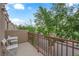 Outdoor patio area with seating, railing, and view of the neighborhood street with mature trees at 9141 Careful Canvas Ave, Las Vegas, NV 89149