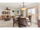 Cozy dining area and living room with carpet, fan, and large windows providing natural light at 9522 Arrowhead Falls Ct, Las Vegas, NV 89148