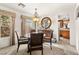 Bright dining area with a round table, carpet, and chandelier leading into the kitchen at 9522 Arrowhead Falls Ct, Las Vegas, NV 89148