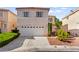 Two-story home featuring a two car garage, manicured landscaping, and a neutral color palette at 9522 Arrowhead Falls Ct, Las Vegas, NV 89148