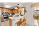 Bright kitchen featuring wood cabinets, stainless steel appliances, tile counters, and a view to the backyard fountain at 9522 Arrowhead Falls Ct, Las Vegas, NV 89148