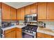 Close up of kitchen showcasing stainless steel appliances and tiled countertops at 9522 Arrowhead Falls Ct, Las Vegas, NV 89148
