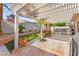 Outdoor patio featuring a pergola, a water feature, artificial turf, and an outdoor dining set for stylish entertaining at 9522 Arrowhead Falls Ct, Las Vegas, NV 89148